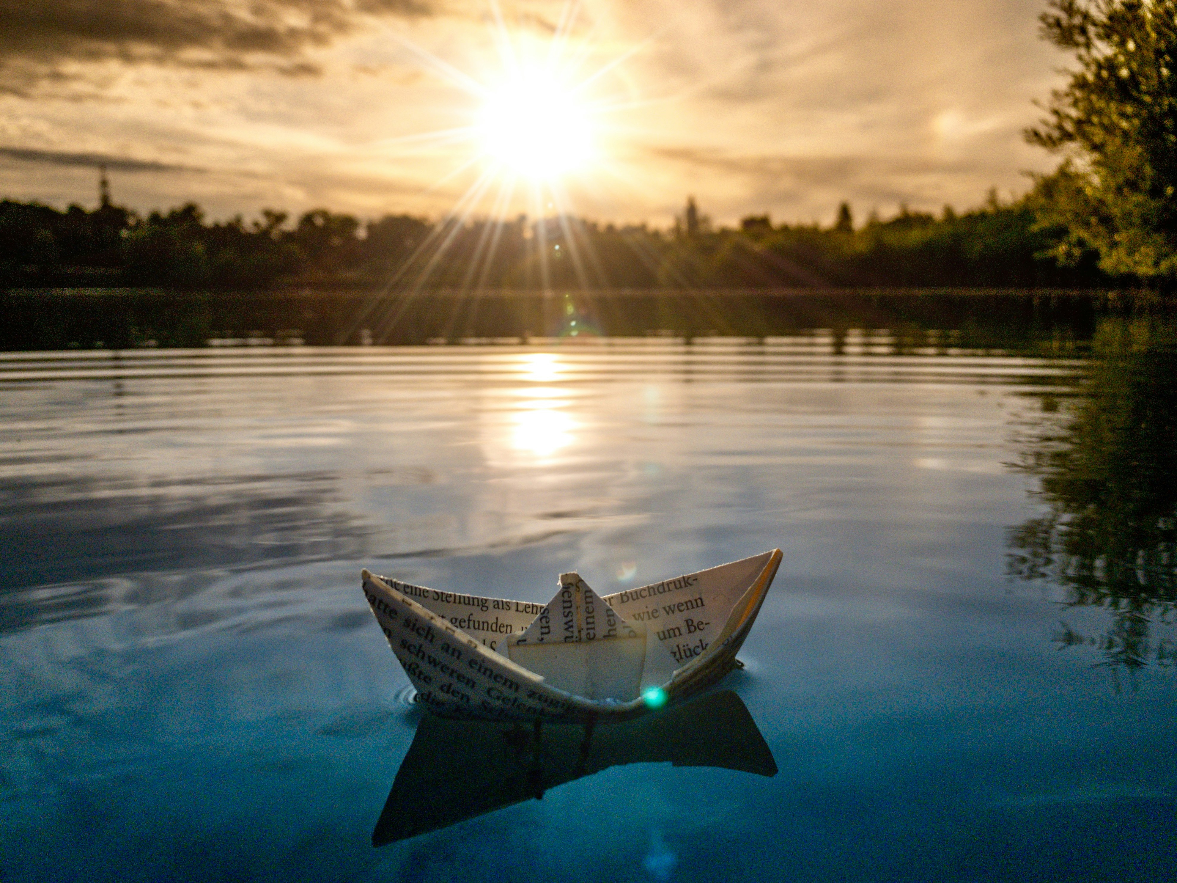 Paper boat symbolizing message or invitation, sent with fragile hope.