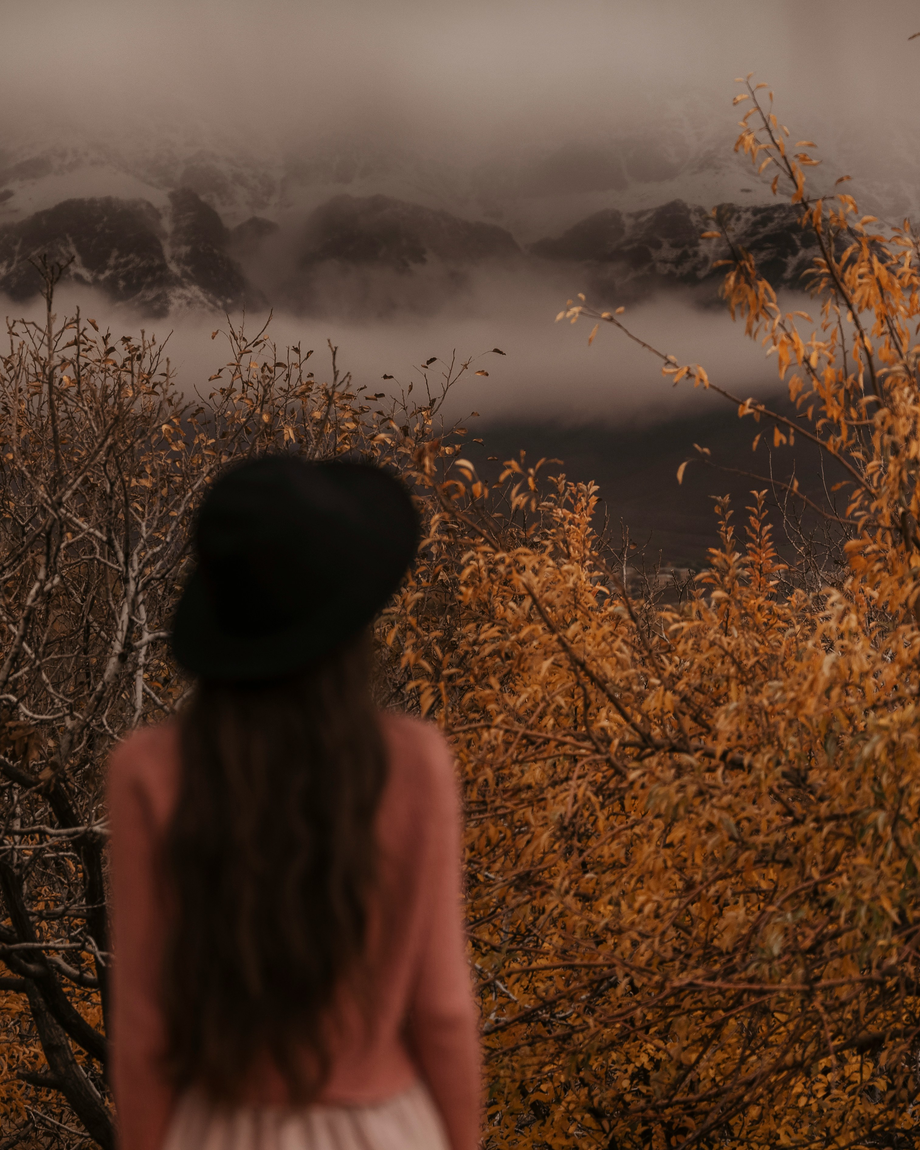 A woman standing in front of a forest.